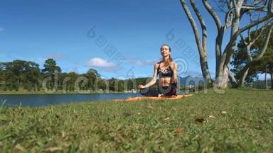 女孩坐在河边绿草上的瑜伽姿势